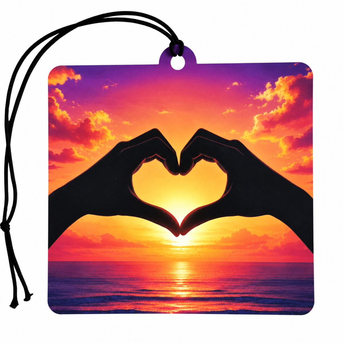 Heart hands sunset car air freshener featuring black silhouetted hands forming a heart against a vibrant pink, orange and purple ocean sunset with black hanging cord.