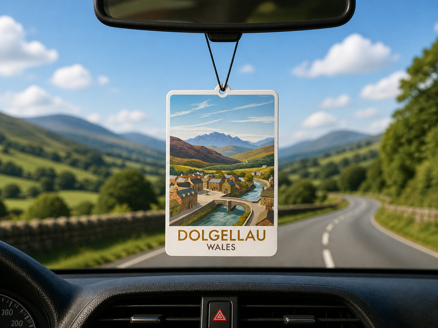 Car air freshener with a scenic view of Dolgellau, Wales hanging from a car's rearview mirror.