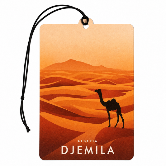 A rectangular travel tag  or car air freshener with a black hanging cord, featuring an illustrated desert scene in orange and brown tones with a camel silhouette and the text 'ALGERIA DJEMILA' at the bottom, shown on a plain white background.