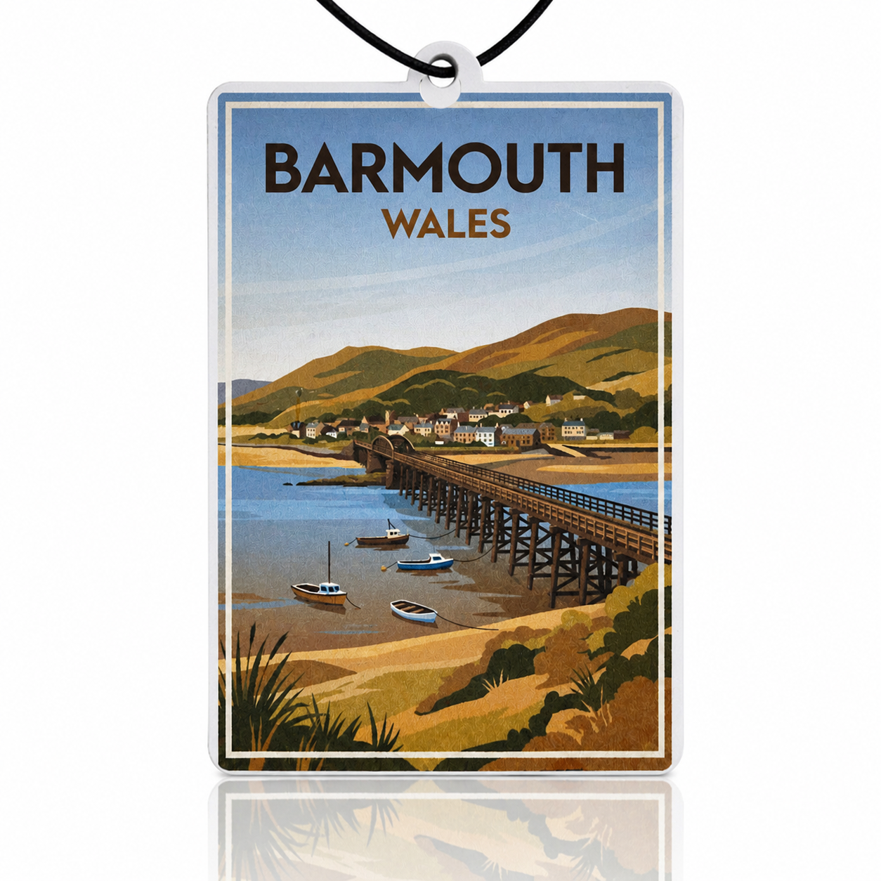 Vintage-style car air freshener of Barmouth, Wales with a bridge over water and boats.