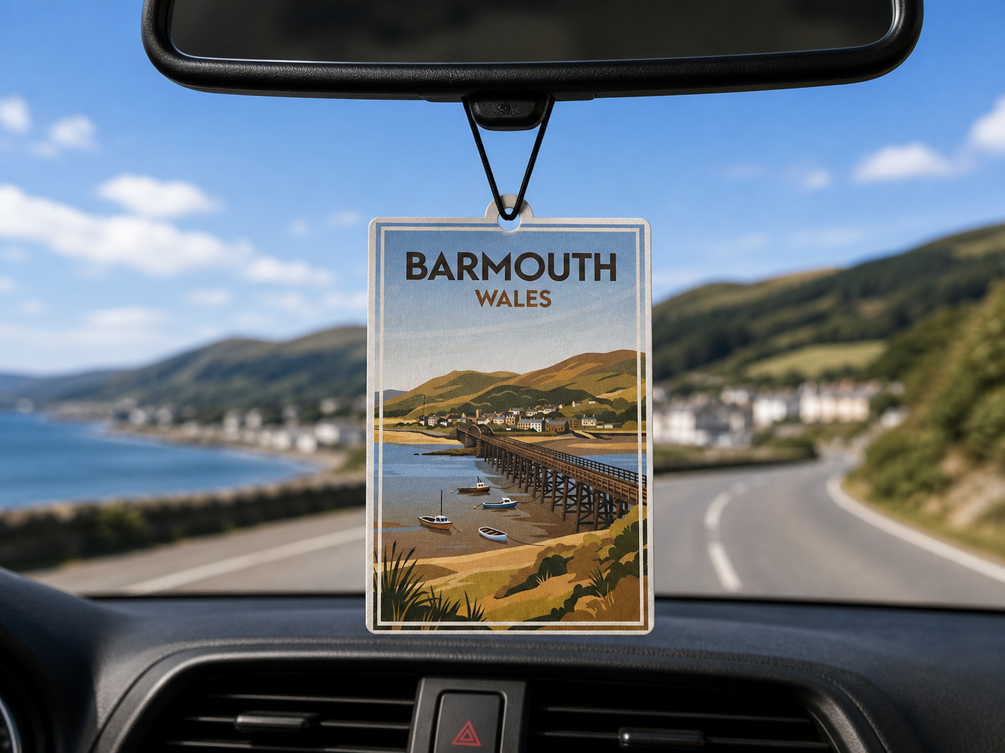 Car air freshener with Barmouth, Wales design hanging from a car's rearview mirror.