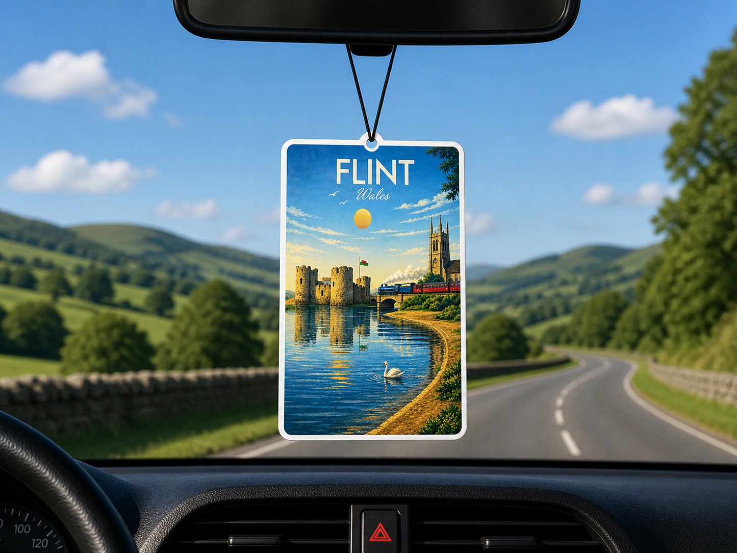 Car air freshener with a scenic view of flint castle and river dee hanging from a car's rearview mirror.
