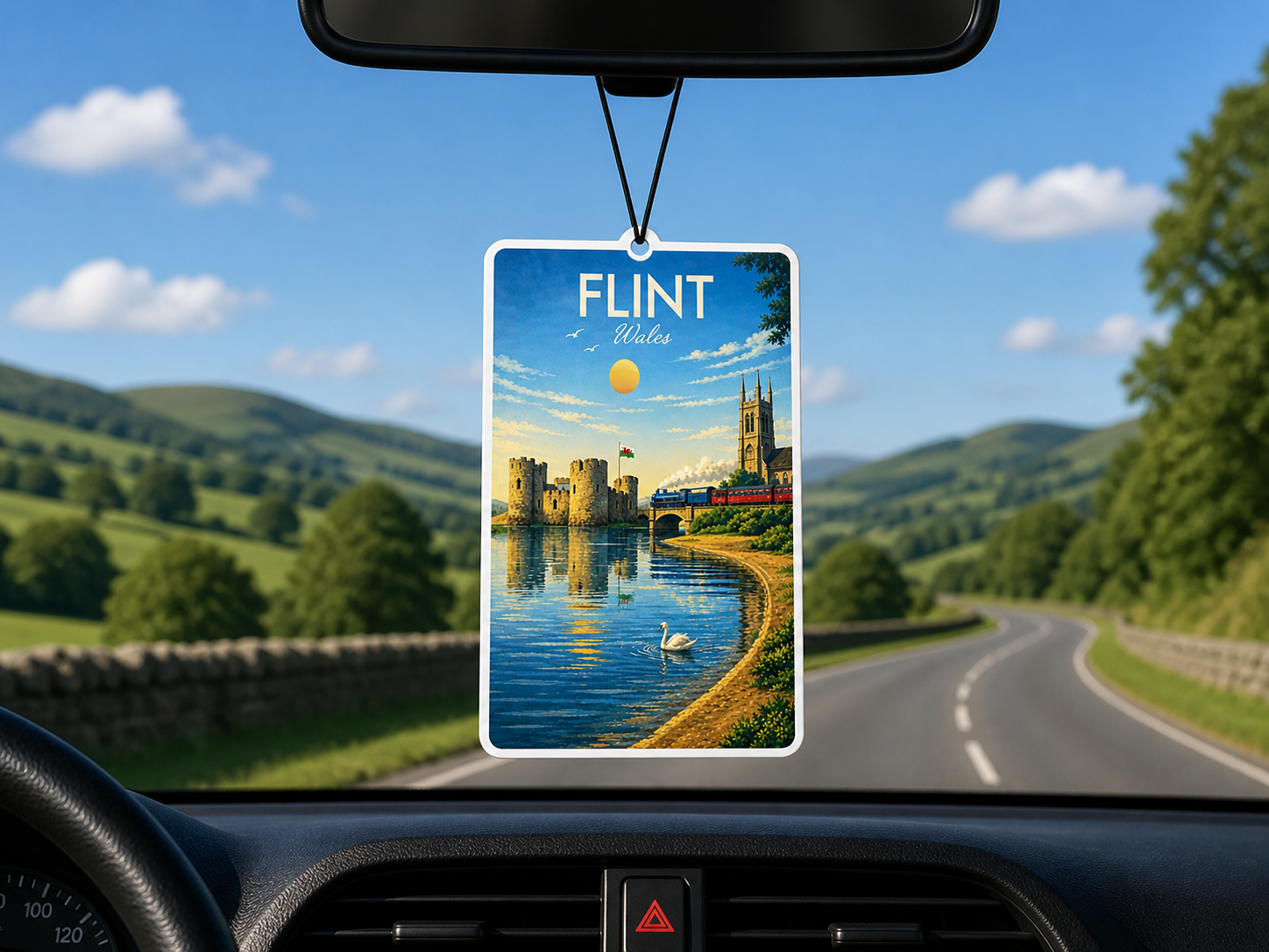 Car air freshener with a scenic view of flint castle and river dee hanging from a car's rearview mirror.
