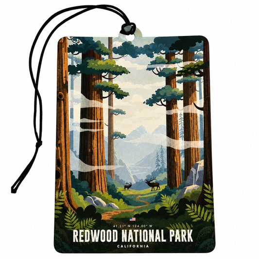 A rectangular hanging tag or car air freshener with a black cord, printed with a stylized forest scene labeled 'REDWOOD NATIONAL PARK' and 'CALIFORNIA.' The artwork shows tall redwood trees, green ferns, distant mountains, and a few deer.