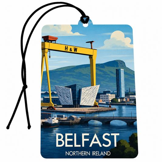 A rectangular travel tag with a black hanging cord car air freshener, featuring a stylized illustration of Belfast, Northern Ireland, including a yellow H&W crane, water, bridge, and mountains. The tag reads “BELFAST” and “NORTHERN IRELAND” at the bottom.