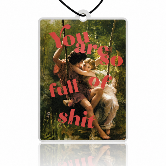 Car air freshener with classical painting of two children on a swing overlaid with red text.