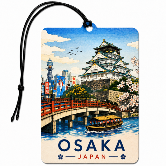A rectangular luggage tag or car air freshener featuring a colorful illustrated scene of Osaka, Japan, with a black hanging cord. The artwork shows a large white castle, a red bridge, blue water, cherry blossoms, and the word 'OSAKA' with 'JAPAN' below.