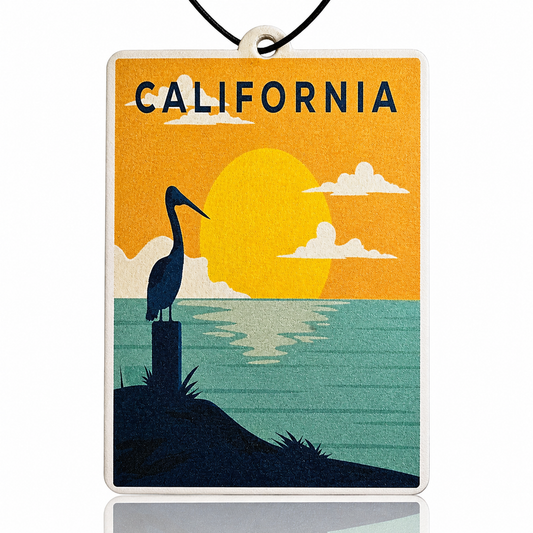 Decorative car air freshener with a pelican silhouette, sunset, and 'California' text on an orange and blue background.